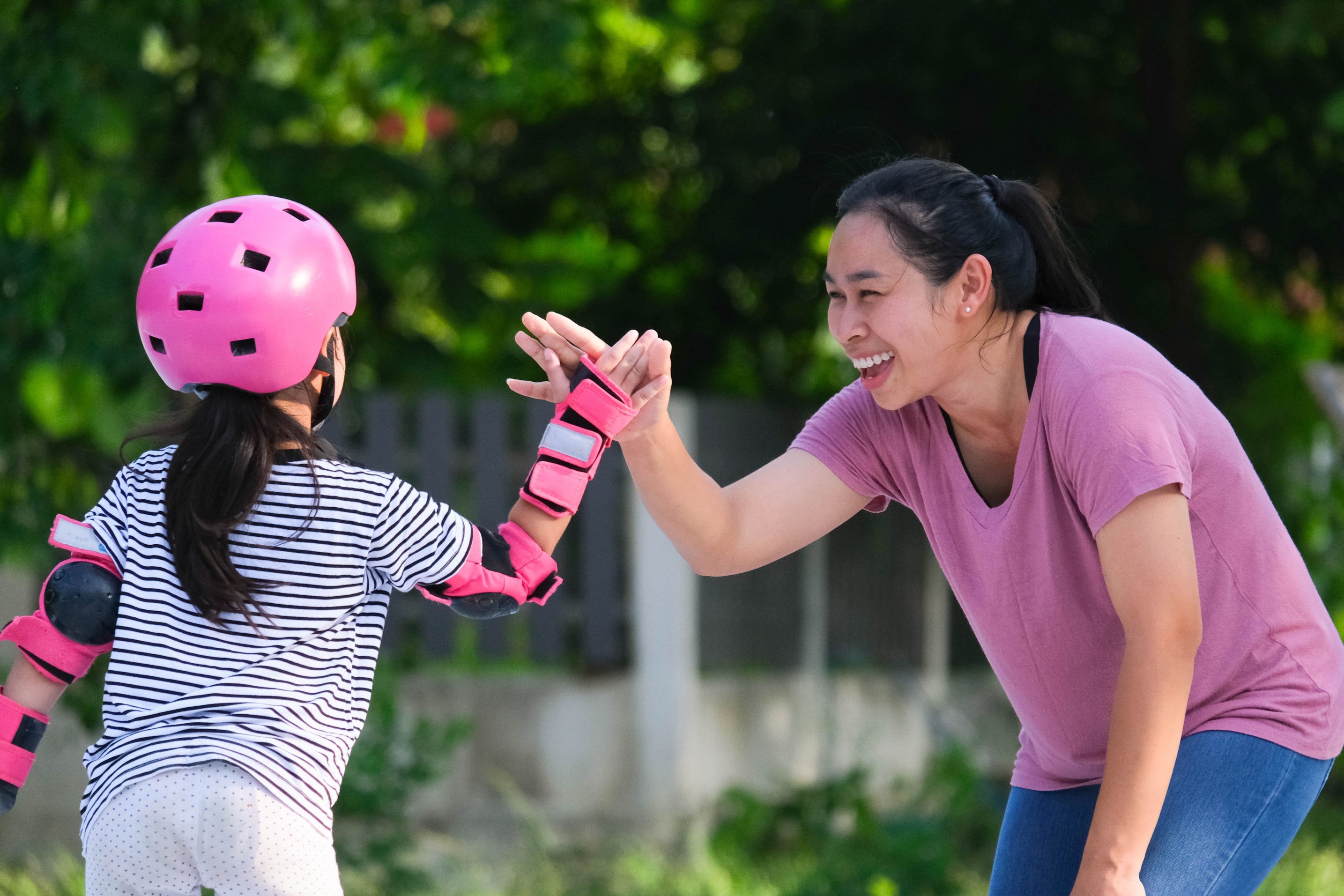 Adult teaching young kid to roller skate